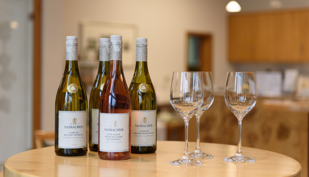 Weinflaschen und Gläser stehen auf einem Tisch in der Vinothek des Sasbacher Winzerkellers